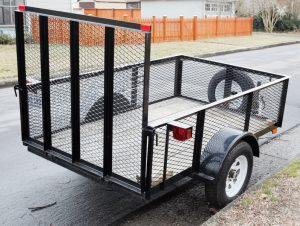 Empty parked utility trailer on residential street. Side and rear view. Horizontal.